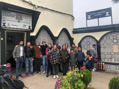 a group of people standing outside of a building at Hôtel Fontaine Campini in Fès