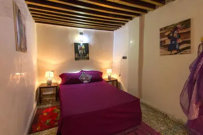 a bedroom with a purple bed in a room at Riad Diwan in Fès