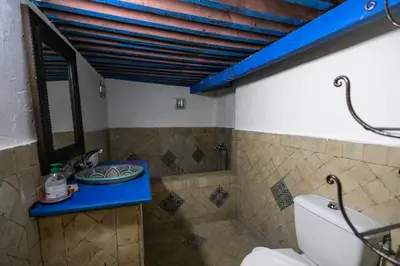 a bathroom with a toilet and a blue counter at Riad Diwan in Fès