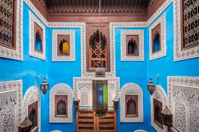 a room with blue walls and ornate windows at Riad Hiba in Meknès