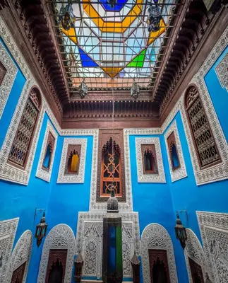 a room with a blue wall with a stained glass ceiling at Riad Hiba in Meknès