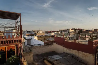 a view of a city with birds flying in the sky at Riad Hiba in Meknès