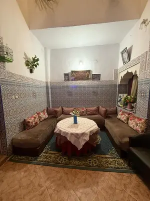 a living room with a couch and a table at Dar Elkorchi in Fès