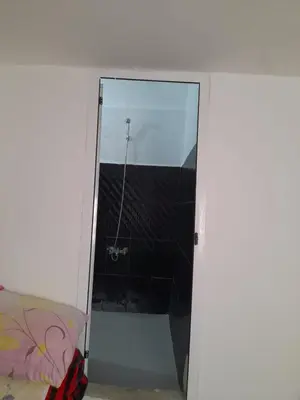 a glass door leading into a bathroom with a shower at Dar Elkorchi in Fès