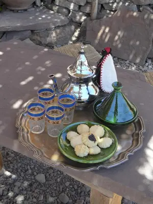 a table with a plate of cookies and a tea set at Gite Tigmi Azrur in Tabant