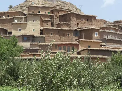a group of houses in front of a mountain at Gite Tigmi Azrur in Tabant