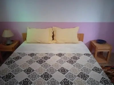 a bed with a black and white quilt on it at Gite Tigmi Azrur in Tabant