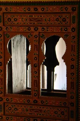 a mirror with two windows with a silhouette of a person at Riad Menthe Et Citron in Meknès