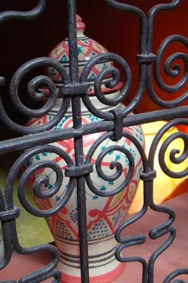 a colorful vase sitting behind a iron fence at Riad Menthe Et Citron in Meknès