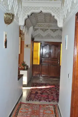 a hallway with a wooden door and a rug at Riad Villa Midelt in Midelt