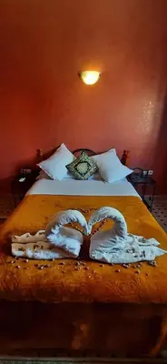 a bedroom with a bed with two towels on it at Hotel Marmar in Ouarzazate