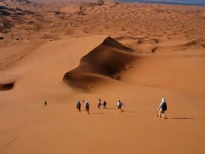 a group of people riding horses through the desert at Hotel Marmar in Ouarzazate