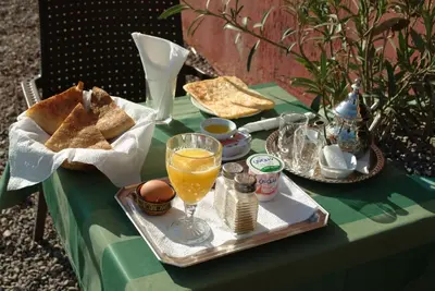 a table with a tray of food and a glass of orange juice at Hotel Marmar in Ouarzazate