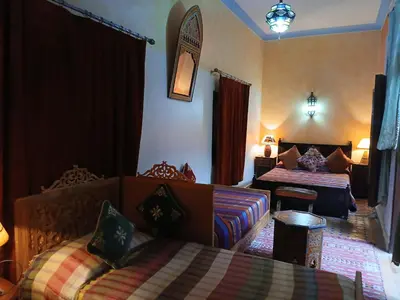 a hotel room with two beds and a couch at Riad Idrissi in Meknès