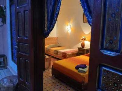 a hotel room with two beds and a door at Riad Idrissi in Meknès