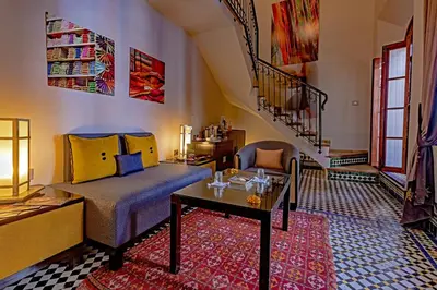 a bedroom with a bed and a table and a staircase at Palais Amani in Fès