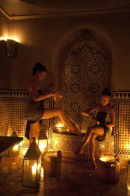 two people are sitting on a wall with lights at Palais Amani in Fès
