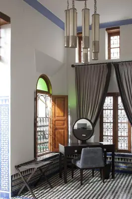 a living room with a table and a mirror at Palais Amani in Fès