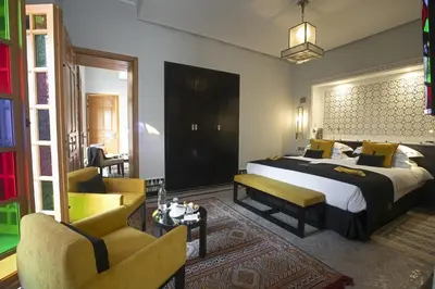 a bedroom with a bed and two chairs in a room at Palais Amani in Fès