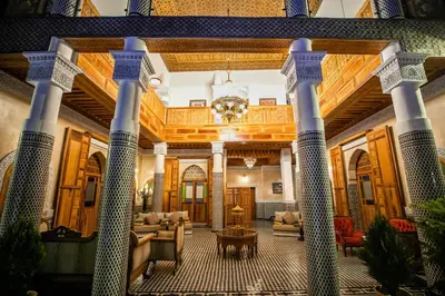 a lobby of a building with columns and a table at Palais Houyam in Fès