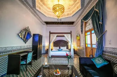 a room with a bed and a couch and a table at Palais Houyam in Fès