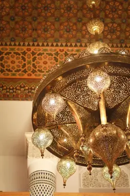 a large gold chandelier hanging from a ceiling at Palais Houyam in Fès