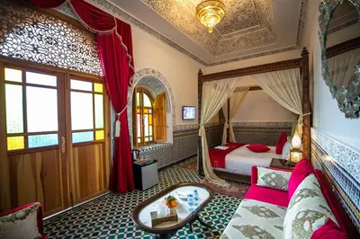 a bedroom with a bed and a couch in a room at Palais Houyam in Fès