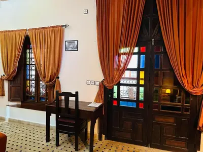 a dining room with a table and a window at Riad Ahlam in Fès