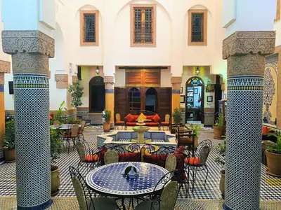 a courtyard with tables and chairs in a building at Riad Ahlam in Fès