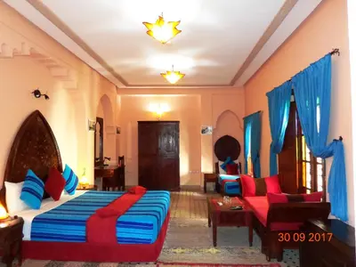 a bedroom with a bed and a couch and a chair at Riad Ahlam in Fès