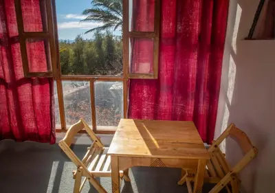 a table and a chair in front of a window at Bassatine Skoura in Skoura
