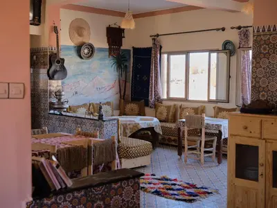 a restaurant with tables and chairs in a room at Panorama chez Hamid in Rissani