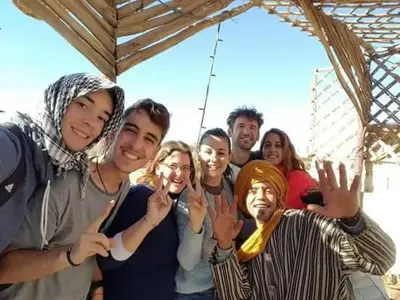 a group of people standing under an umbrella at Panorama chez Hamid in Rissani