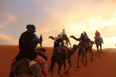 a group of people riding horses in the desert at Panorama chez Hamid in Rissani