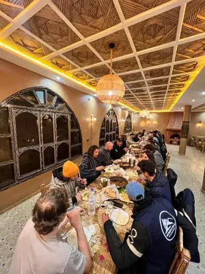 a group of people sitting at a long table at Paradis Touareg in Zagora