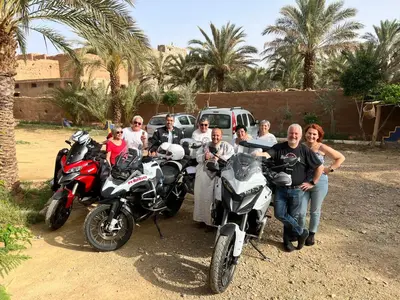 a group of people posing for a picture next to motorcycles at Paradis Touareg in Zagora