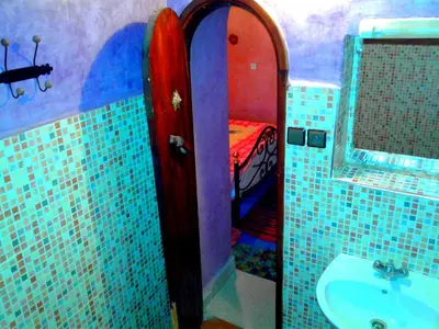 a bathroom with a sink and a bed in a room at Kasbah Tiriguioute in Skoura