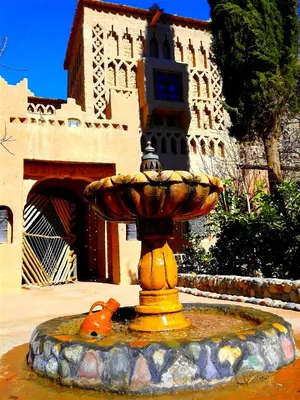 a yellow fountain in front of a building at Kasbah Tiriguioute in Skoura
