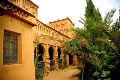 an old building with pink flowers in a courtyard at Kasbah Tiriguioute in Skoura
