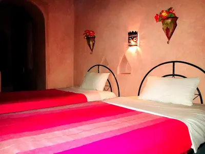 two beds sitting next to each other in a room at Kasbah Tiriguioute in Skoura