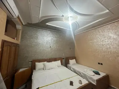 a small room with two beds and a ceiling at Dar Calme Chez El Bouhali in Skoura