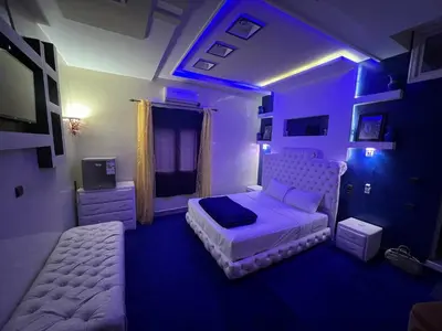 a bedroom with a bed and a couch and a tv at Dar Calme Chez El Bouhali in Skoura