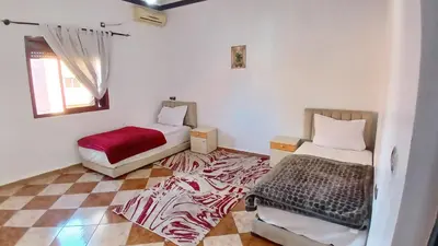 a small room with two beds and a rug at Residence Rosas in Ouarzazate