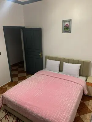a bedroom with a bed with a pink comforter at Residence Rosas in Ouarzazate