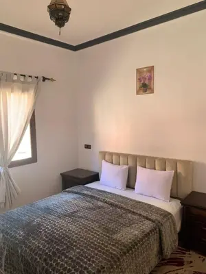 a bedroom with a bed with two pillows and a window at Residence Rosas in Ouarzazate