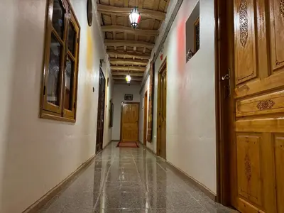 an empty hallway with a wooden ceiling and a door at Hotel Restaurant Camping Berbère de la Montagne in Imdiazene