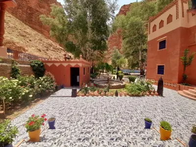 a courtyard with potted plants and a building at Hotel Restaurant Camping Berbère de la Montagne in Imdiazene