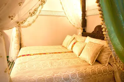 a bedroom with a canopy bed with pillows at Riad-Boutique Borj Dhab Fez in Fès