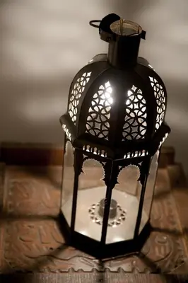 a black lantern sitting on top of a table at Dar KamalChaoui in Bhalil