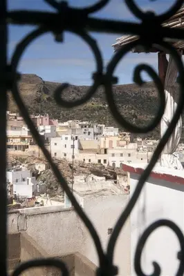 a view of a city through a iron fence at Dar KamalChaoui in Bhalil